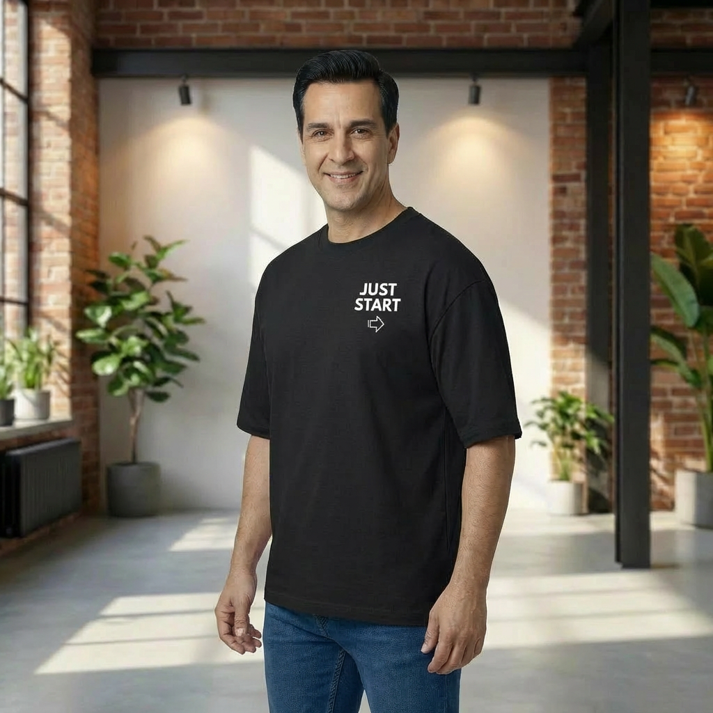Man wearing a black t-shirt with 'JUST START' text in a modern indoor setting