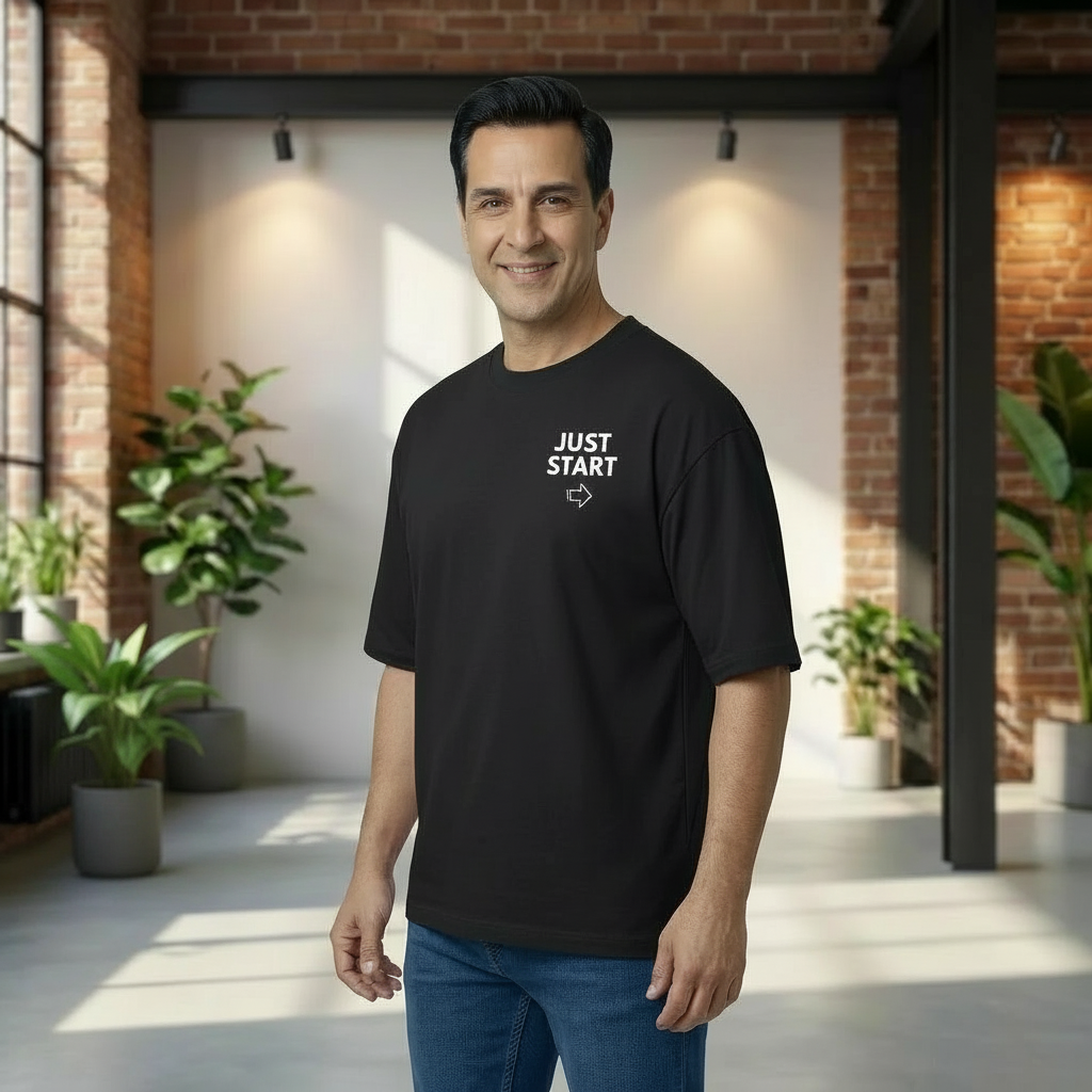 Man wearing a black t-shirt with 'JUST START' text in a modern indoor setting