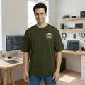 Man wearing an olive green t-shirt with a light owl ogo in a home office setting