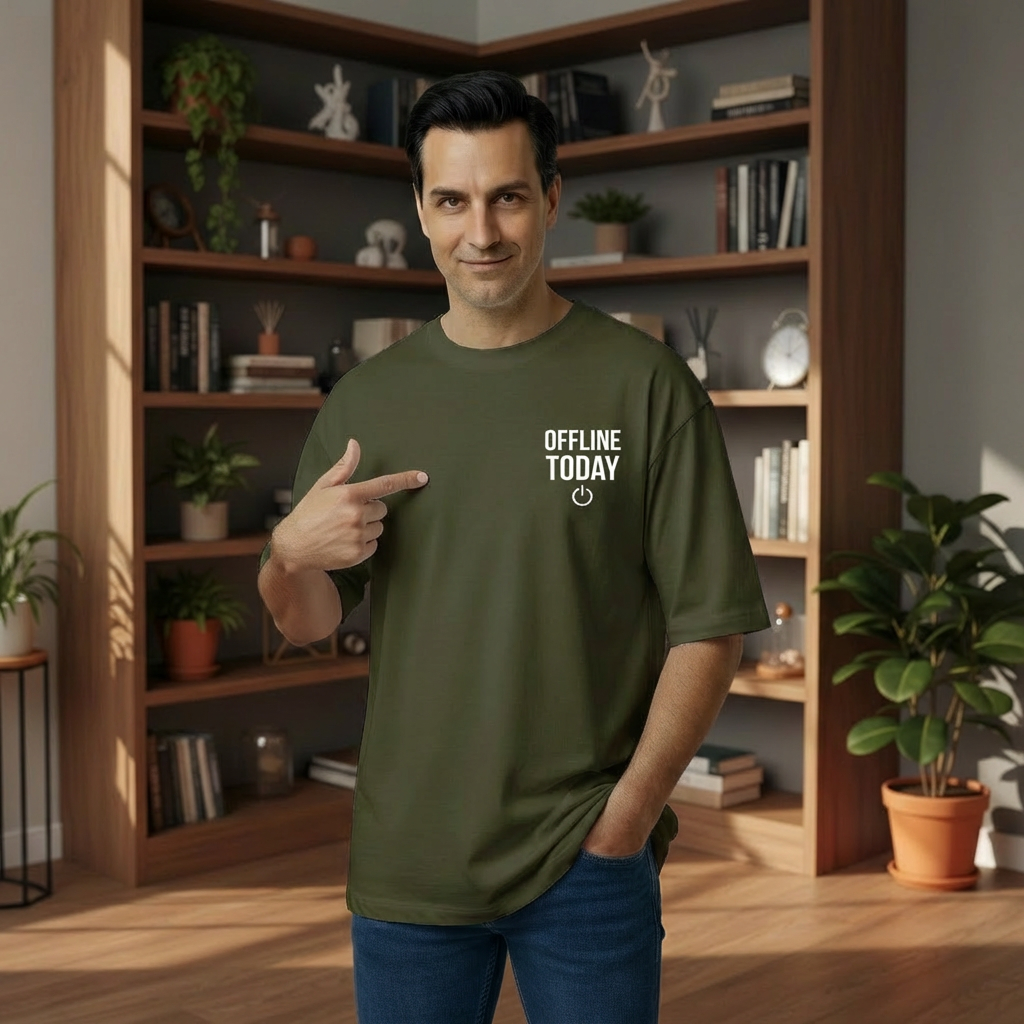 Man pointing to a 'Offline Today' t-shirt in a room with bookshelves and plants.