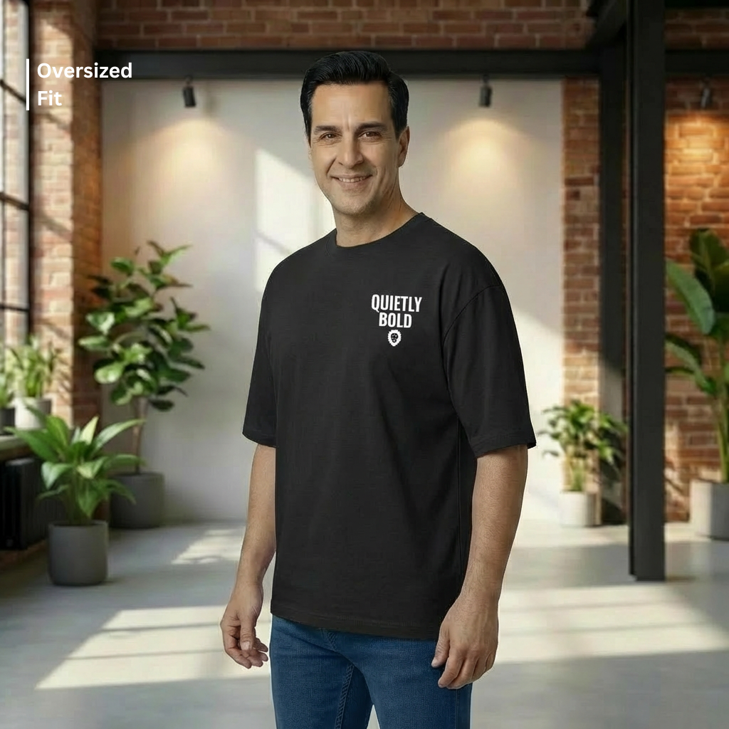 Man wearing a black t-shirt with 'Quietly Bold' text in a modern indoor setting