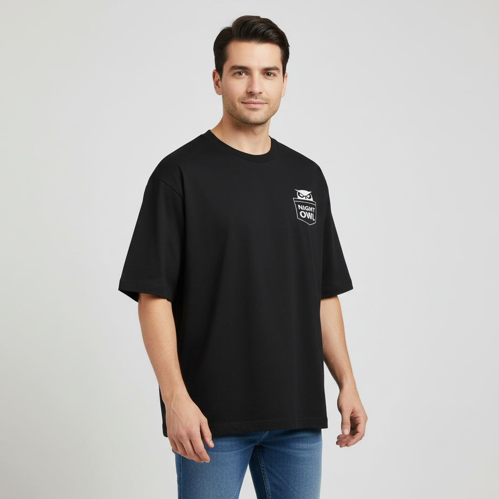 Man wearing a black oversized t-shirt with a logo on a gray background